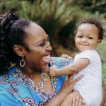 Decorative showing a smiling mother in a blue top with a smiling infant.